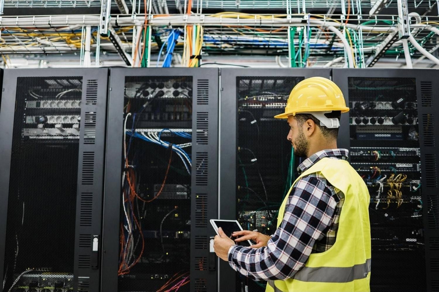 IT technician checking server racks and cabling during an office relocation in the UAE